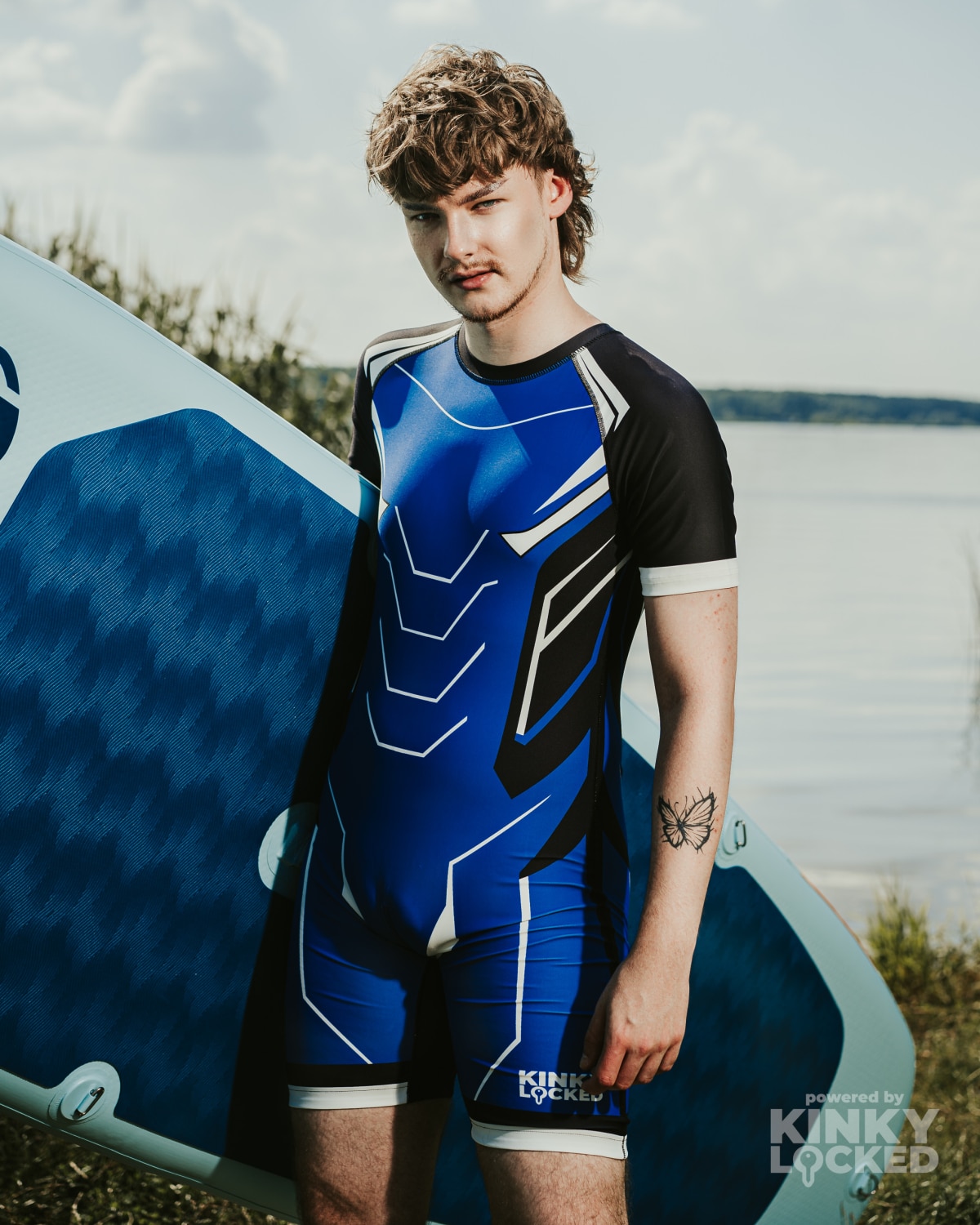 KINKY LOCKED Midnight Blue Surfsuit beside a paddleboard