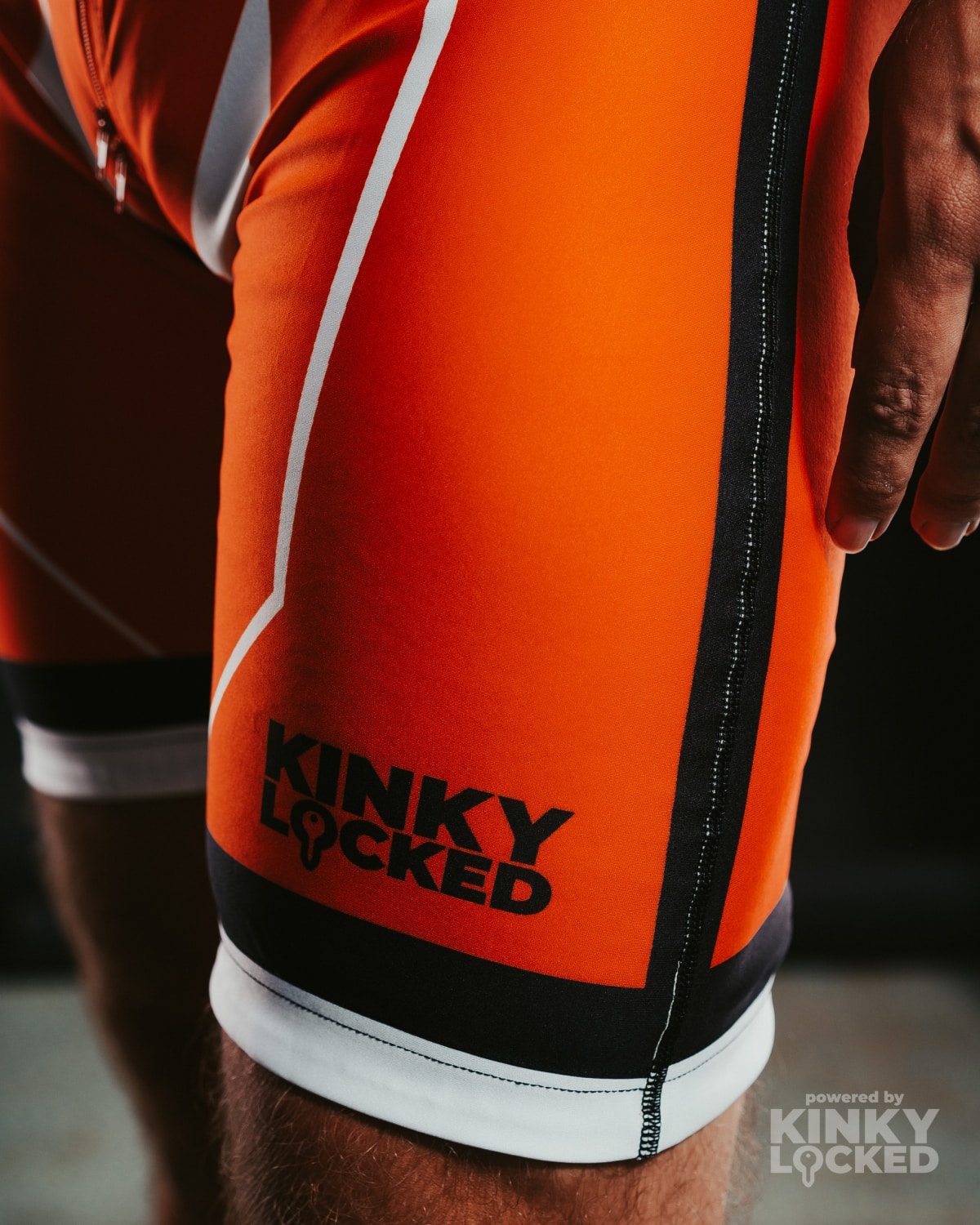 Close-up of the Neon Orange Surfsuit lower slider and KINKY LOCKED logo